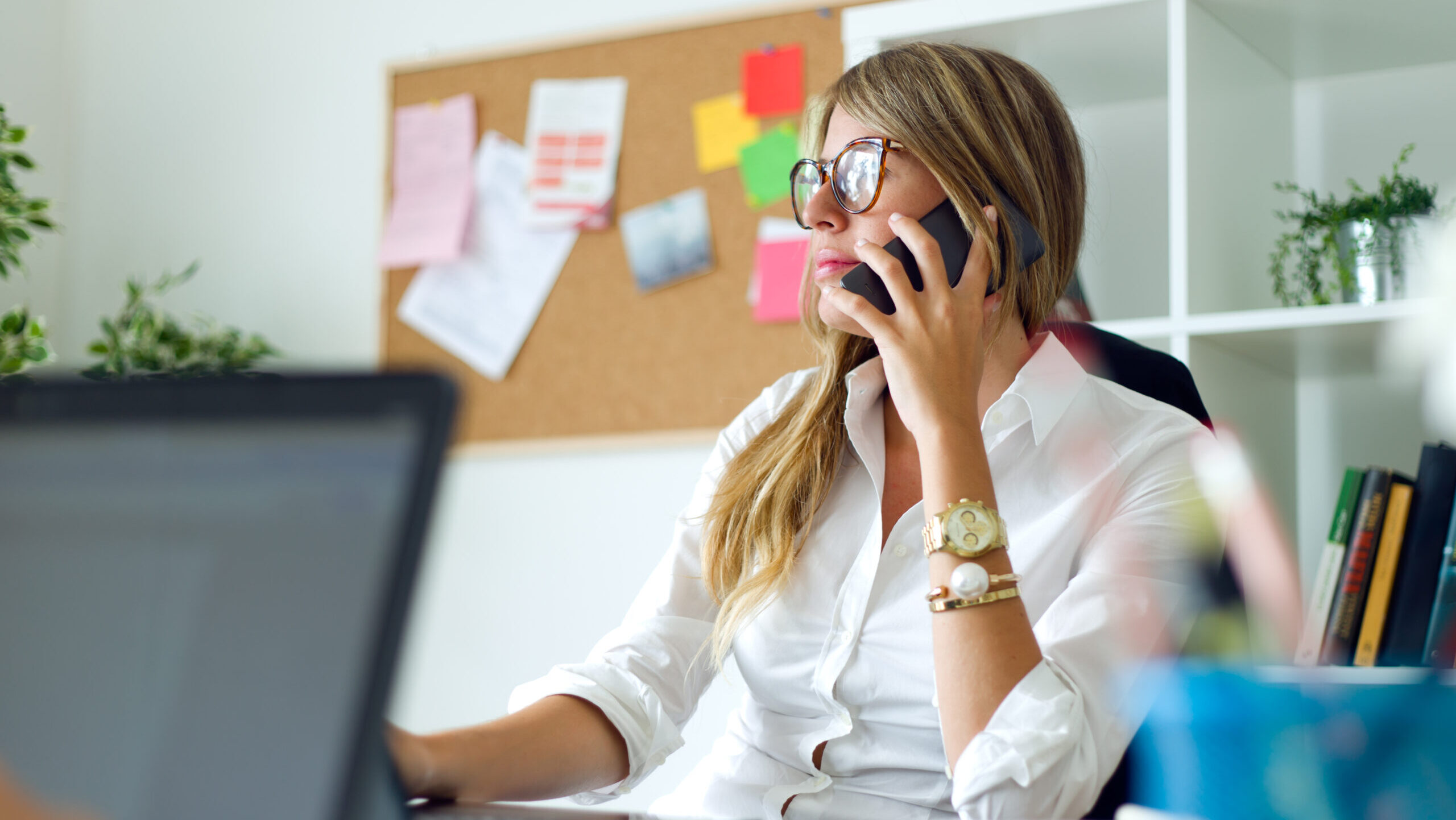 Portrait of business woman working with mobile phone in her office.